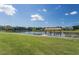 Enjoy this view of the community pond, featuring a covered pergola with bench seating and lush green lawn at 404 Lily Pad Ct, Zebulon, NC 27597