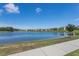 View of the neighborhood from across the community pond, including a sidewalk and lush green lawn at 404 Lily Pad Ct, Zebulon, NC 27597