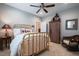 Bright bedroom with a gold-toned metal frame bed, a ceiling fan, and a large wooden storage cabinet at 4331 Millcreek Cir, Pittsboro, NC 27312
