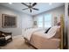 Comfortable bedroom featuring neutral walls, a ceiling fan, a rocking chair, and a light-filled window at 4331 Millcreek Cir, Pittsboro, NC 27312