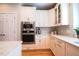 Gourmet kitchen with stainless steel appliances and white cabinets and hardwood floors at 4331 Millcreek Cir, Pittsboro, NC 27312
