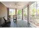 Relaxing screened porch with wicker chairs, ceiling fan, and serene views of the surrounding trees and foliage at 4331 Millcreek Cir, Pittsboro, NC 27312