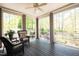Relaxing screened porch with wicker chairs, ceiling fan, and serene views of the surrounding trees and foliage at 4331 Millcreek Cir, Pittsboro, NC 27312