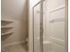 Well-lit bathroom featuring a shower and convenient built-in shelving at 4501 Forest Dr, Holly Springs, NC 27540