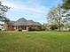 Wide view of a brick house from the backyard, surrounded by an extensive lawn and landscaping at 4501 Forest Dr, Holly Springs, NC 27540