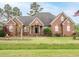 Charming brick home with a well-maintained lawn and mature landscaping under a partly cloudy sky at 4501 Forest Dr, Holly Springs, NC 27540