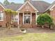 Inviting front entrance featuring a brick facade, decorative columns, and manicured landscaping at 4501 Forest Dr, Holly Springs, NC 27540