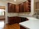 Traditional kitchen with dark cabinets, light countertops, and stainless steel dishwasher at 4501 Forest Dr, Holly Springs, NC 27540