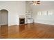 Spacious living room with hardwood floors, a fireplace, built-in shelving, and large windows with shutters at 4501 Forest Dr, Holly Springs, NC 27540