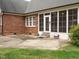 Back of a brick home featuring a sunroom with multiple windows and a small patio area at 4501 Forest Dr, Holly Springs, NC 27540