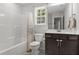 Bright bathroom with a shower-tub combo, dark vanity and a window at 479 Kotata Ave, Bunnlevel, NC 28323
