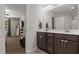 Bathroom features dark cabinets, double sinks, tile flooring and adjoins to a bedroom at 479 Kotata Ave, Bunnlevel, NC 28323