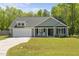 Charming single-story home with a well-manicured lawn and inviting front porch with rocking chairs at 479 Kotata Ave, Bunnlevel, NC 28323