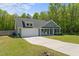 Lovely home with a two-car garage, neutral siding, and a green lawn, set against a backdrop of lush trees at 479 Kotata Ave, Bunnlevel, NC 28323