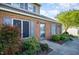 Close up of a townhome exterior with brick, blue shutters, and a tidy garden at 48 Fashion Pl, Durham, NC 27705