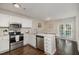 Bright kitchen with white cabinets, quartz countertops, stainless steel appliances, and a dining area at 48 Fashion Pl, Durham, NC 27705
