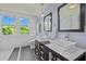 Stylish bathroom featuring dual sinks, mirrors, a toilet, and bright windows with natural light at 501 Mallard Ave, Durham, NC 27701