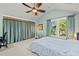 Relaxing bedroom with a ceiling fan, large windows and curtains, and a bed for comfortable sleeping at 501 Mallard Ave, Durham, NC 27701
