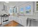 Well-lit kitchen featuring white cabinets, stainless steel appliances, and large windows at 501 Mallard Ave, Durham, NC 27701