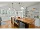 Bright kitchen with white cabinetry, butcher block island with seating, and modern lighting fixtures at 501 Mallard Ave, Durham, NC 27701