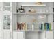 Built-in shelving unit with a gray backsplash, white cabinets, and decorative elements at 501 Mallard Ave, Durham, NC 27701