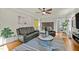 Comfortable living room with leather seating, ceiling fan, a striped rug, and hardwood flooring at 501 Mallard Ave, Durham, NC 27701