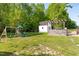 The backyard features a swing set, a storage shed, and a stone grill with a pergola-covered outdoor kitchen at 5525 Sandy Trail Dr, Knightdale, NC 27545