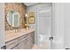 Stylish bathroom with decorative wallpaper, round mirror, and gray vanity with marble countertop at 5525 Sandy Trail Dr, Knightdale, NC 27545