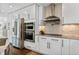 Modern kitchen featuring stainless steel appliances, white cabinets, and a cooktop at 5525 Sandy Trail Dr, Knightdale, NC 27545