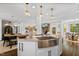 Open floor plan with kitchen island, stainless steel sink, and views into other rooms at 5525 Sandy Trail Dr, Knightdale, NC 27545