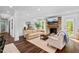 Bright living room with a stone fireplace, ample seating, and hardwood flooring at 5525 Sandy Trail Dr, Knightdale, NC 27545