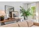 Neutral living room with a wooden console table, decorations, and large windows at 5525 Sandy Trail Dr, Knightdale, NC 27545