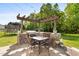 Outdoor dining area with stone BBQ and Pergola on stone patio at 5525 Sandy Trail Dr, Knightdale, NC 27545