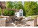 Outdoor entertaining area with built-in grill, dining table, comfortable seating, and storage shed at 5525 Sandy Trail Dr, Knightdale, NC 27545