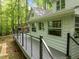 A spacious back deck with black metal railings overlooks the wooded backyard of this inviting residence at 608 Valen Ct, Chapel Hill, NC 27516