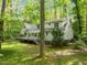 A backyard view of the house featuring a deck, trees, and a lush green lawn at 608 Valen Ct, Chapel Hill, NC 27516