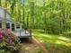 Wooden deck overlooking a lush backyard with mature trees and vibrant azalea bushes, perfect for outdoor living at 608 Valen Ct, Chapel Hill, NC 27516