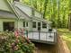 Home exterior with deck and grill backing up to wooded area, with pink azalea at 608 Valen Ct, Chapel Hill, NC 27516