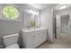 Bright bathroom with double vanity, round window, and neutral paint at 608 Valen Ct, Chapel Hill, NC 27516