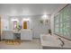 Spacious bathroom featuring double sinks, a vanity, garden tub, and framed botanical art at 608 Valen Ct, Chapel Hill, NC 27516