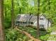 Beautiful home nestled among mature trees with a brick walkway winding through the verdant landscape at 608 Valen Ct, Chapel Hill, NC 27516