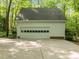 White two car garage with concrete driveway surrounded by trees and lush greenery at 608 Valen Ct, Chapel Hill, NC 27516
