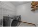 Laundry room featuring vinyl floors, neutral paint, wire shelving, and modern washer/dryer unit at 608 Valen Ct, Chapel Hill, NC 27516