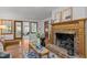 Close up of the fireplace, with wooden mantle and brick surround in an inviting, naturally lit living room at 608 Valen Ct, Chapel Hill, NC 27516