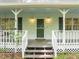 Inviting front porch with classic white railings, dark green door, and decorative lighting fixtures at 608 Valen Ct, Chapel Hill, NC 27516