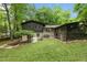 Large backyard with lush lawn, mature trees, and screened-in porch at 6421 Arrington Rd, Raleigh, NC 27607