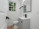 Bright bathroom features a gray vanity, modern fixtures and a window at 6421 Arrington Rd, Raleigh, NC 27607