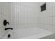 This tiled bathtub features a modern black faucet and a white tiled wall with built-in niche at 6421 Arrington Rd, Raleigh, NC 27607