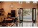 Inviting dining area with open doors showcasing outdoor views, a unique light fixture, and an adjacent kitchen at 665 Lonach Ln, Roxboro, NC 27574