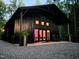 Stunning exterior of a modern black home featuring a gravel driveway and inviting porch with rocking chairs at 665 Lonach Ln, Roxboro, NC 27574